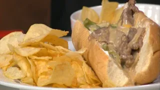 Chef prepares the famous Philly cheesesteak sandwich with steak, cheese, onions, and bell peppers