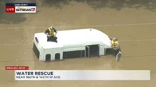 Two People On Top of Van Rescued From High Water