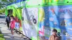 Two MTA buses covered in original artwork from MD artists to celebrate Earth Day