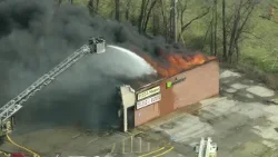 Fire crews spray water onto burning business plaza in Smithville, Missouri