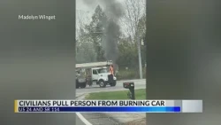 Civilians pull person from burning car