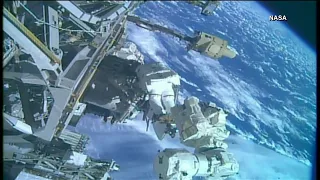 Two astronauts do some repair work outside ISS