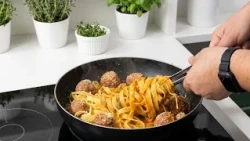 Homemade-style Fettuccine Bolognese with golden meatballs and fresh Parmesan