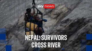 Survivors in Nepal cross flooded Nepali river in high wire metal cage
